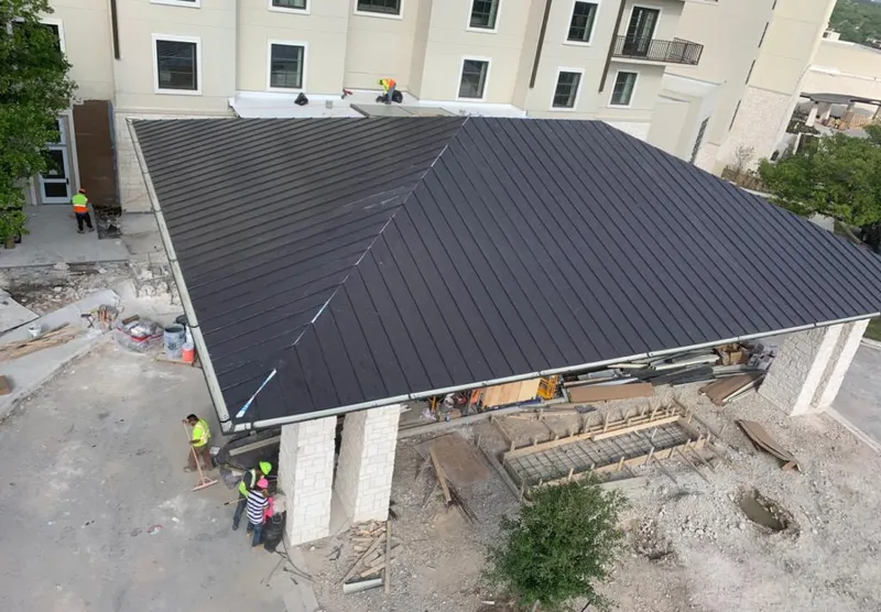 Metal roofing installation team working on a commercial building in Talent